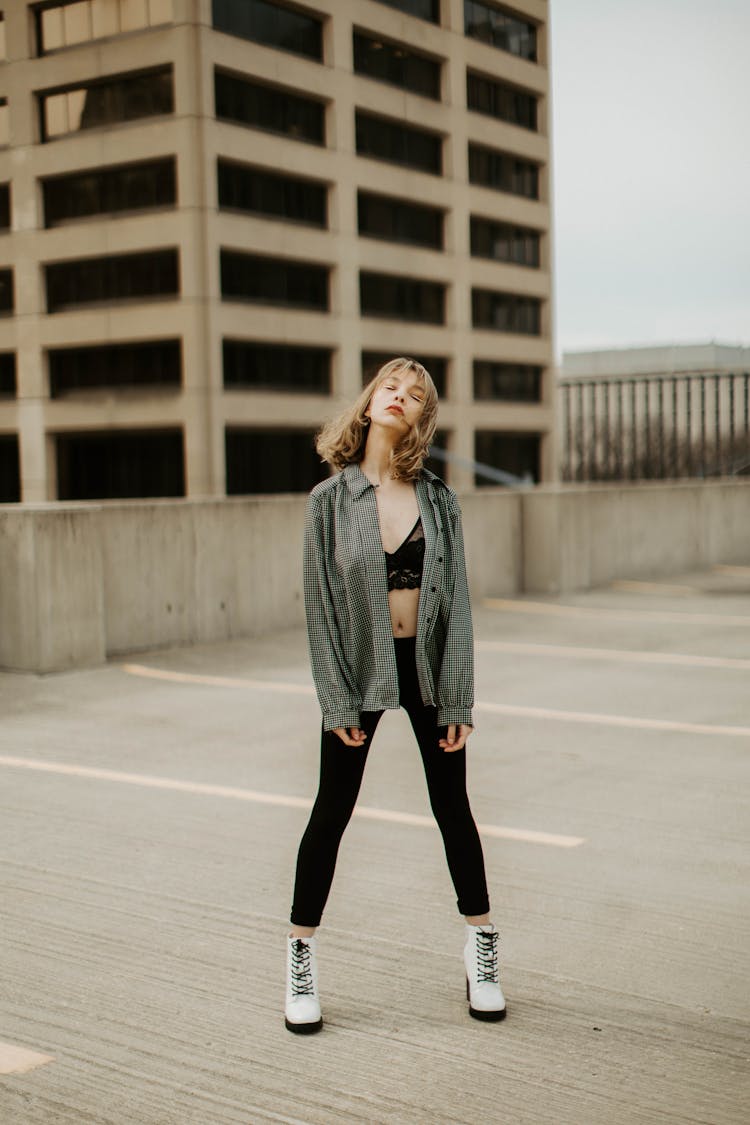 Woman In Button Down Shirt Standing At A Parking Lot