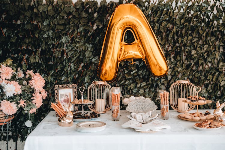 An Inflatable Letter On Backdrop Near Dessert Bar