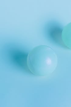A simple and modern image of a light blue ball on a matching background, offering creative copyspace.