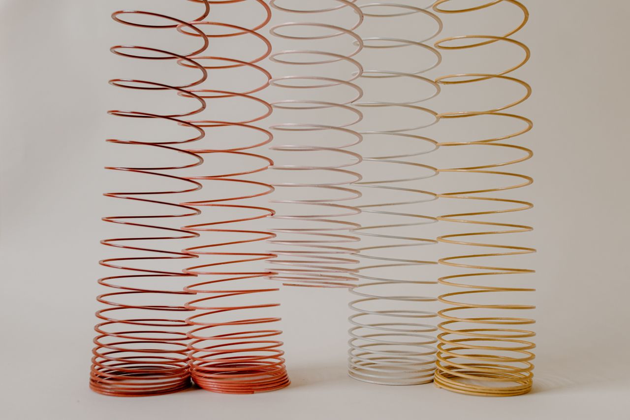 a collection of colorful slinkies elegantly arranged against a neutral