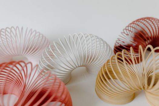 Creative arrangement of colorful slinkies on a pastel background. Perfect for playful designs.