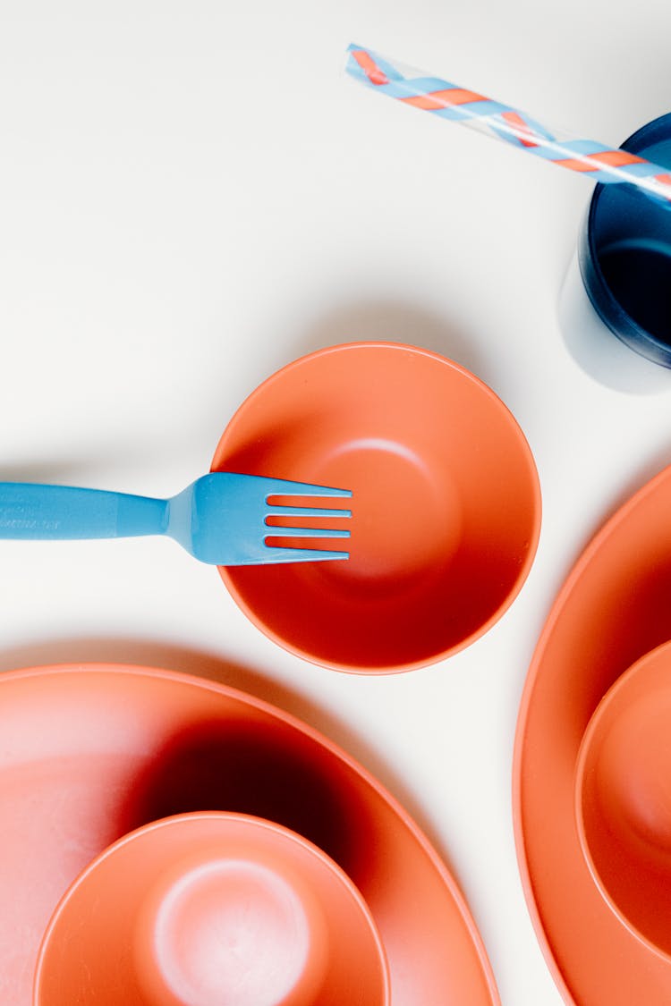 Blue Plastic Spoon On Red Round Plate