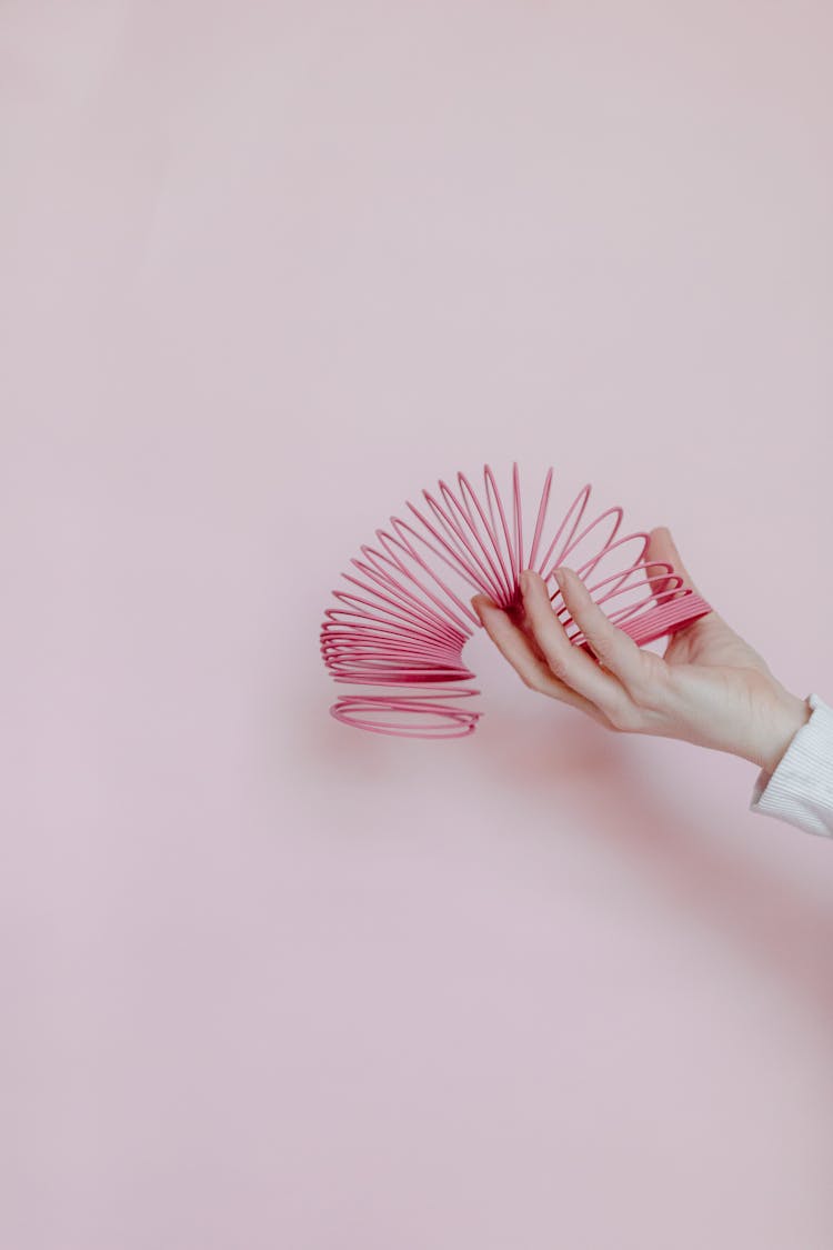 A Person Playing A Slinky Spring Toy