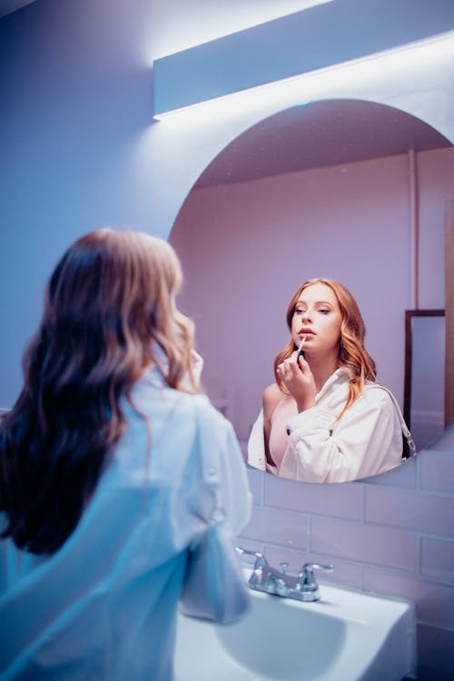 A Woman Putting on a Lipstick