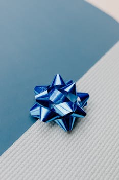 A striking blue ribbon placed on a textured white and blue background, perfect for decorations.