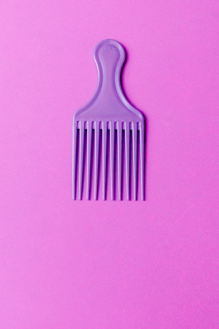 A Purple Hair Comb On Purple Surface