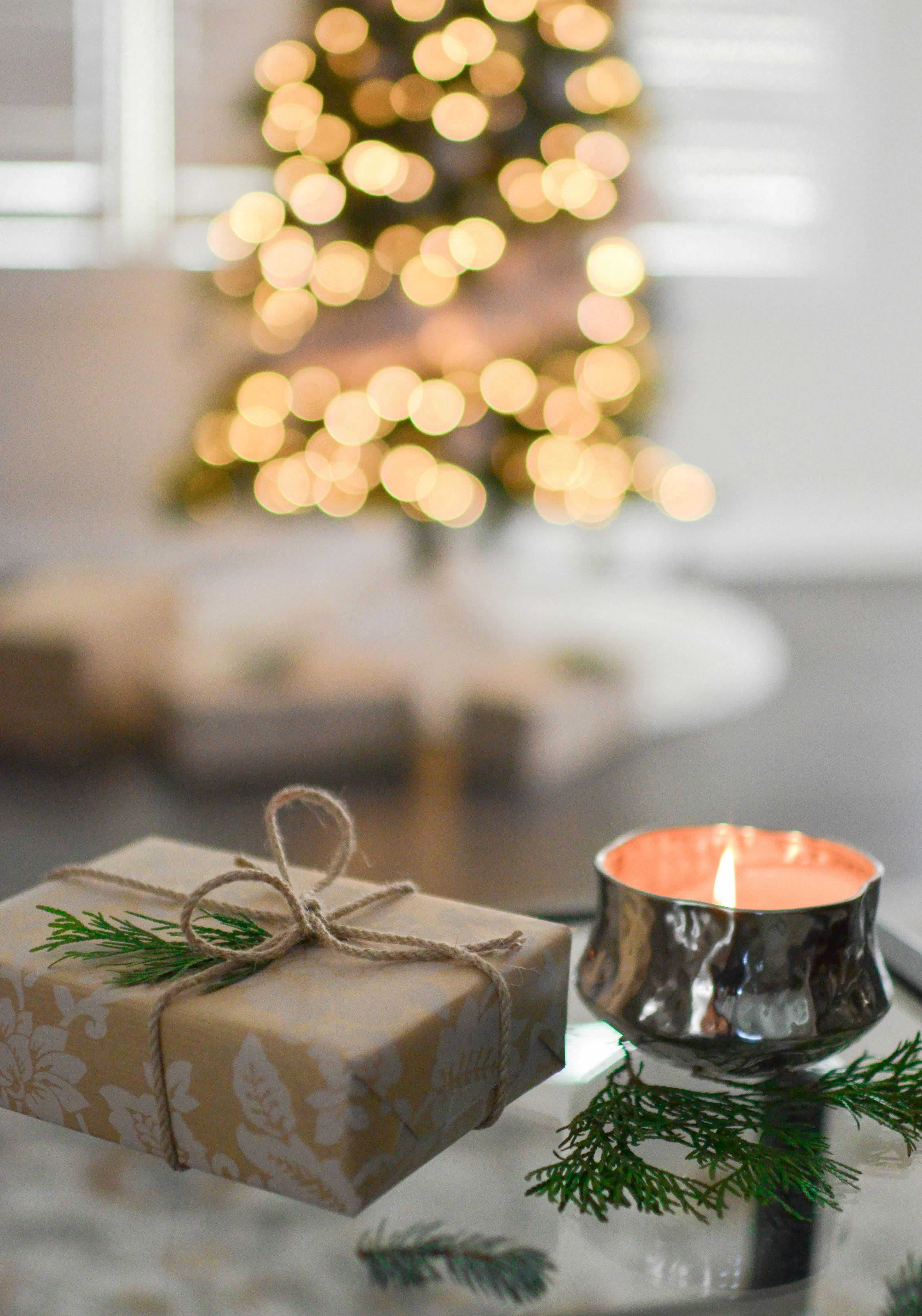 close up photography of gift besides candle