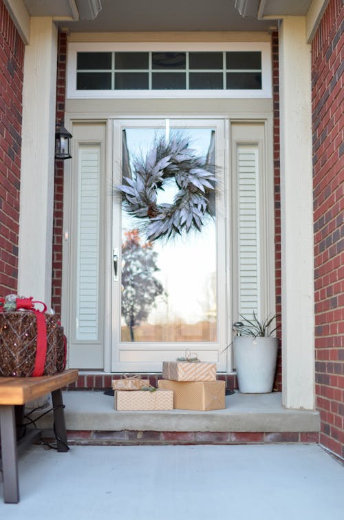 Free Four Brown Gift Boxes Near a Glass Paneled Door With Wreath Stock Photo