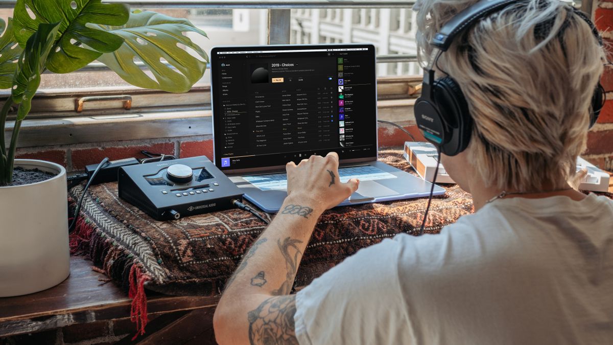 Music producer working with headphones and digital audio software