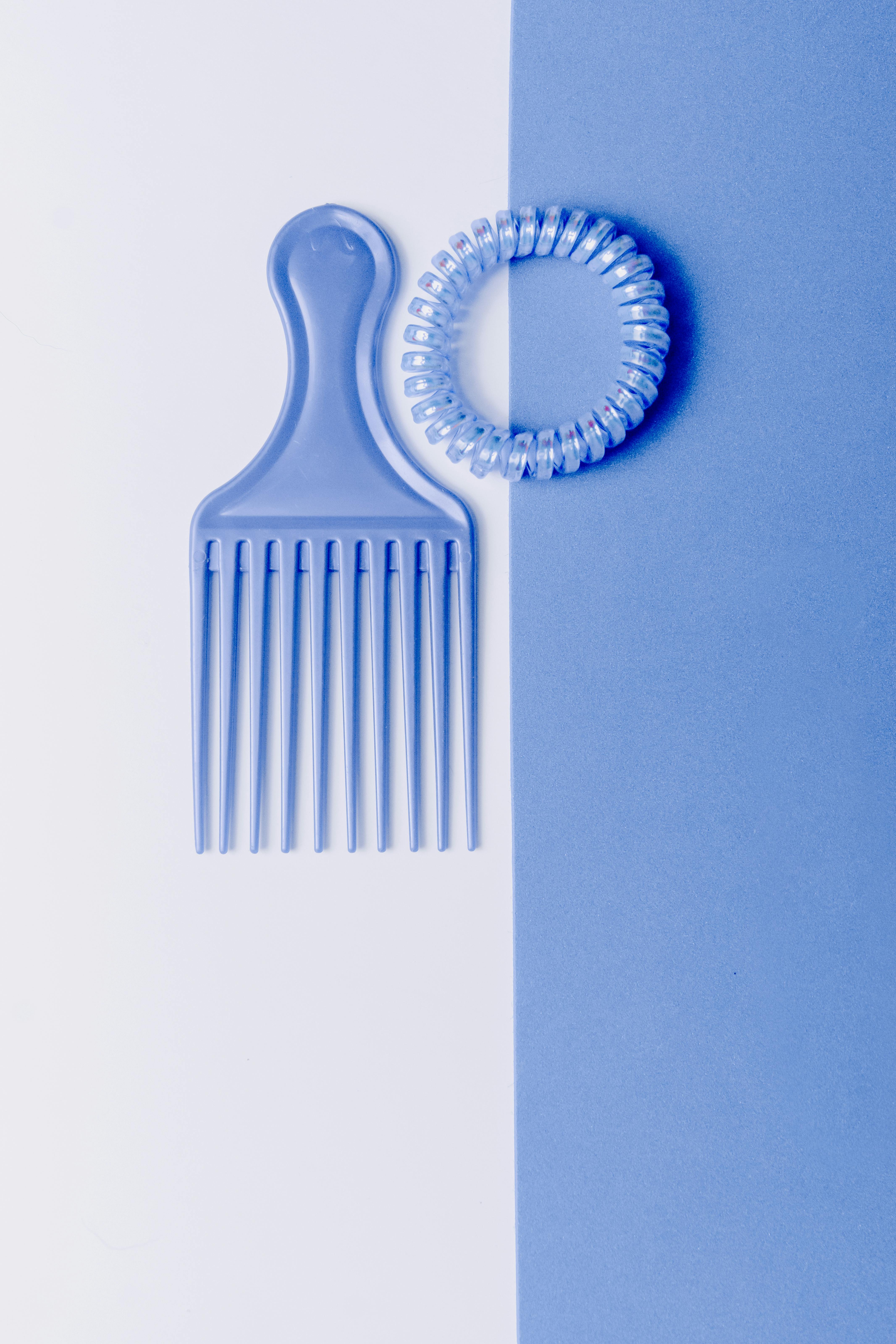 Blue Hair Comb and Spiral Hair Tie on Blue and White Surface · Free Stock Photo