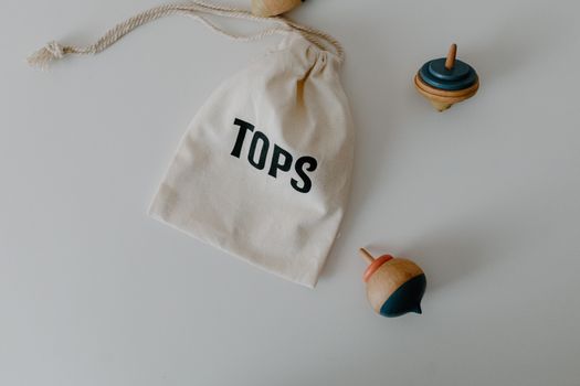 Wooden Toy Tops Beside a String Bag