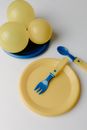 Yellow Egg and Blue Handled Fork on Yellow Plate