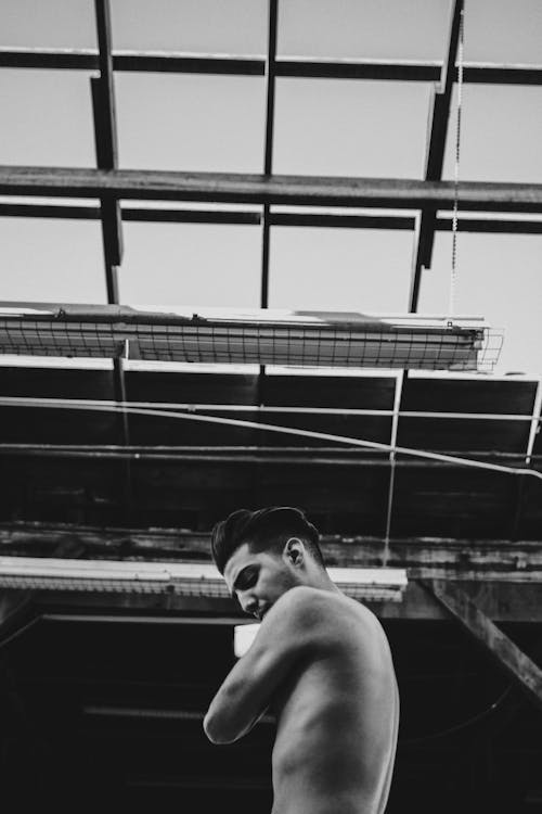 Grayscale Photo of Topless Man Posing at the Camera