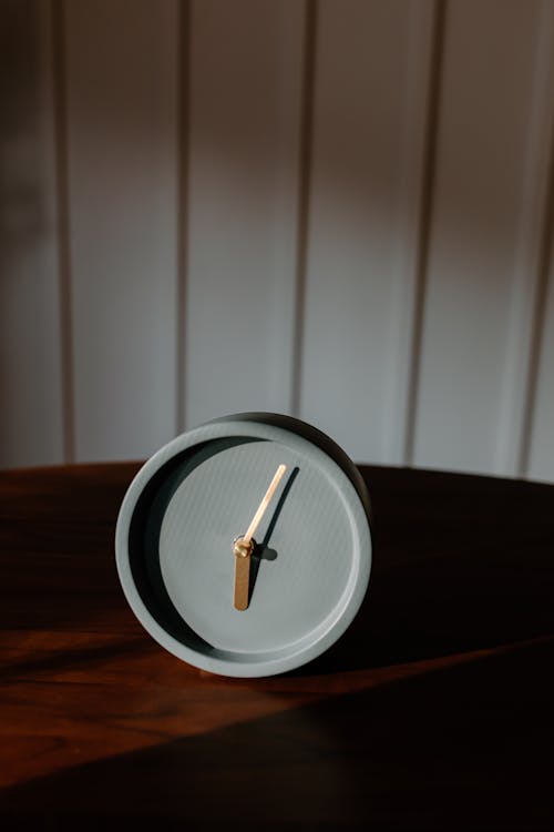 An Analogue Modern Design Clock in the Wooden Table