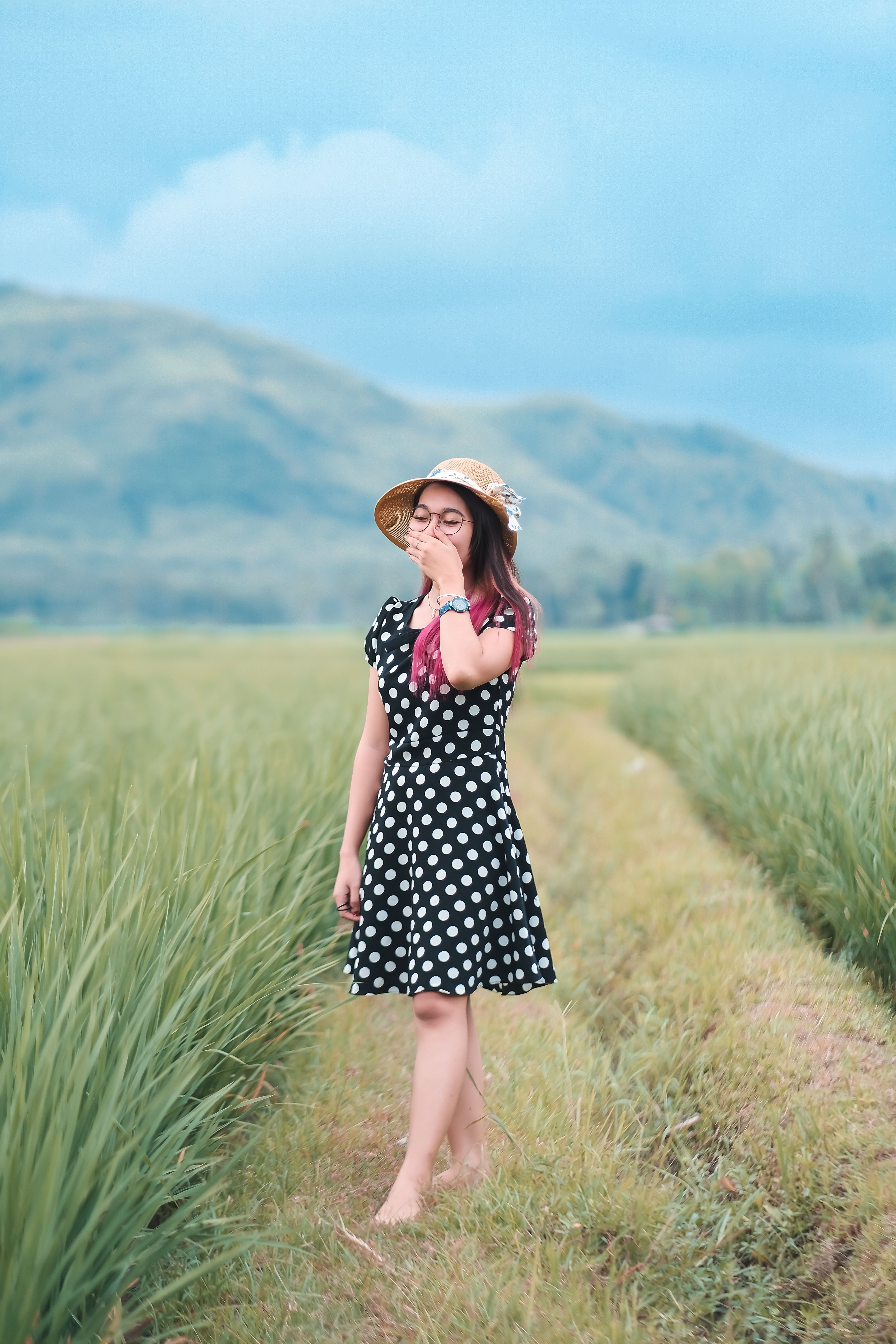 A Woman in Black Polka Dot Dress Standing on a Grassy Field · Free ...