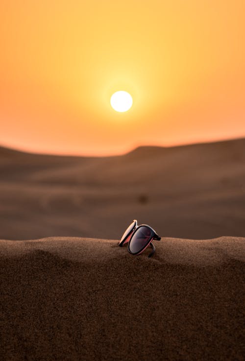 Free Wayfarer Sunglasses on Sand Tilt Shift Lens Photography Stock Photo