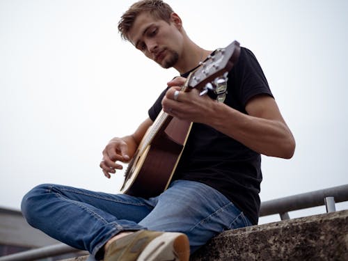 Free Low-Angle Shot of a Man Playing Acoustic Guitar Stock Photo