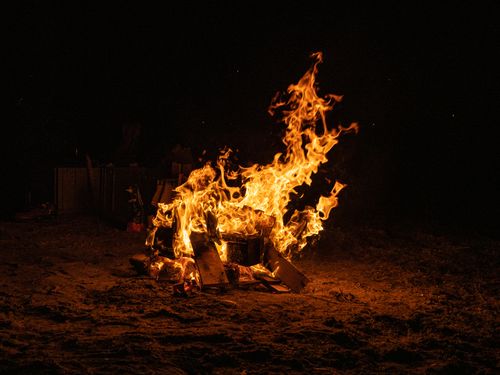Free A blazing campfire with tall flames against a dark night backdrop. Stock Photo