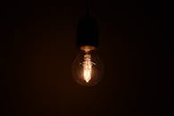 一张特写图中，发光的灯泡在黑暗环境中散发出温暖的光