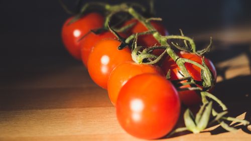 Free Vibrant cherry tomatoes on a vine highlighting freshness and organic appeal. Stock Photo
