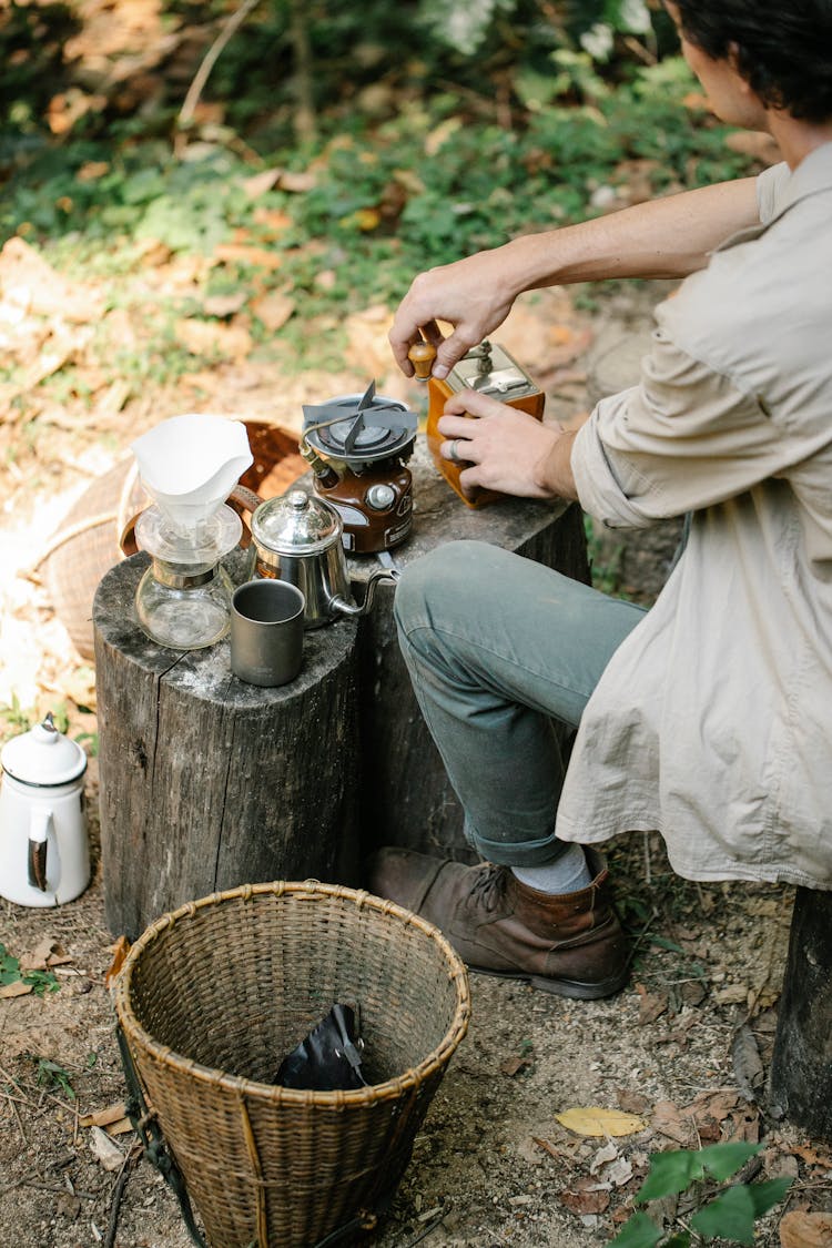 Crop Farmer Grinding Coffee On Stump In Countryside