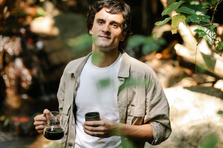 Man With Mug And Aromatic Coffee In Garden