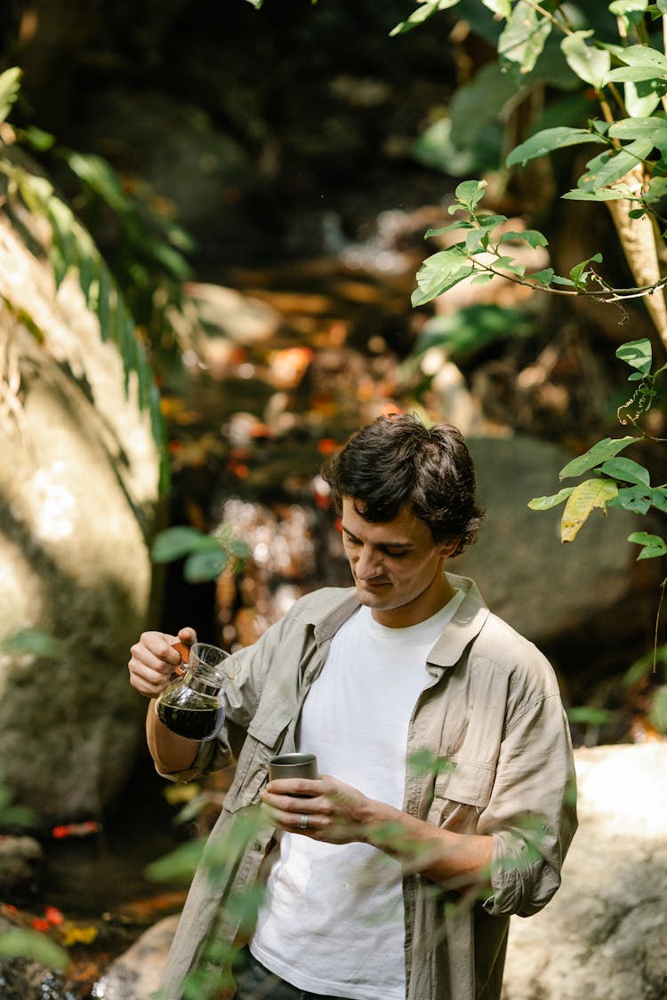 Man With Mug And Coffee In Jug Outdoors