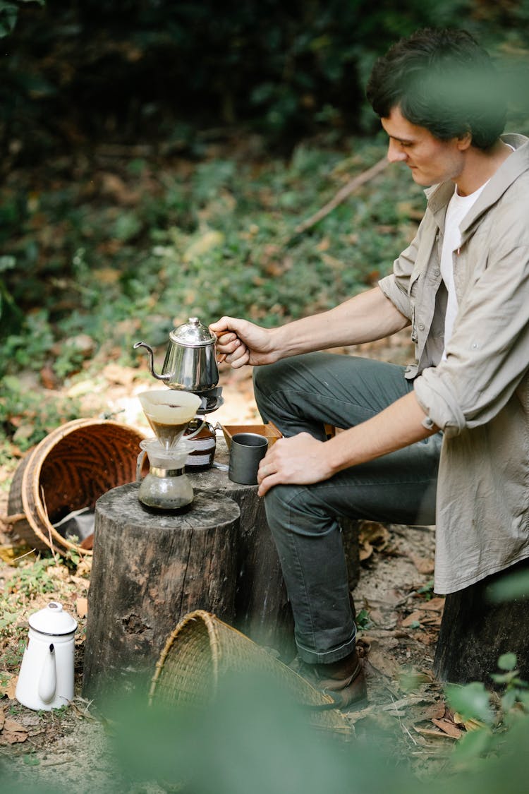 Farmer Brewing Coffee On Stump In Countryside