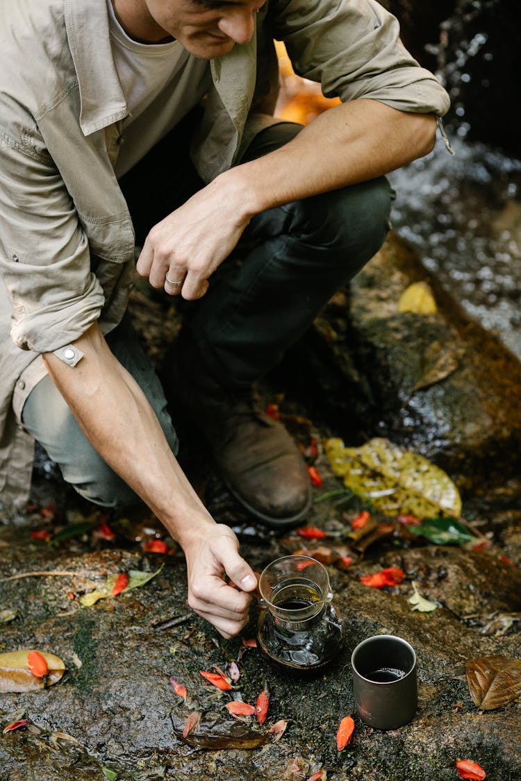 Young Male Traveler Brewing Coffee In Chemex Coffeemaker During Hiking Trip