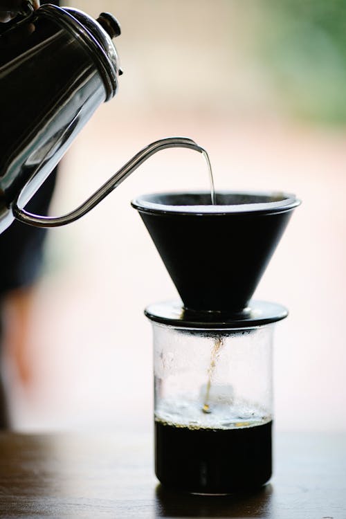 Free Anonymous barista poring water into cup while brewing filter coffee Stock Photo