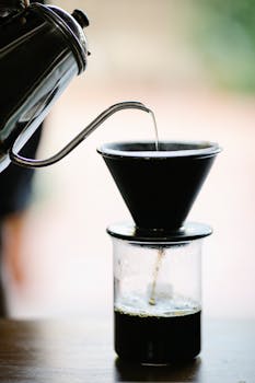 Close-up of the pour over coffee brewing method with kettle and filter, capturing a homemade coffee experience.