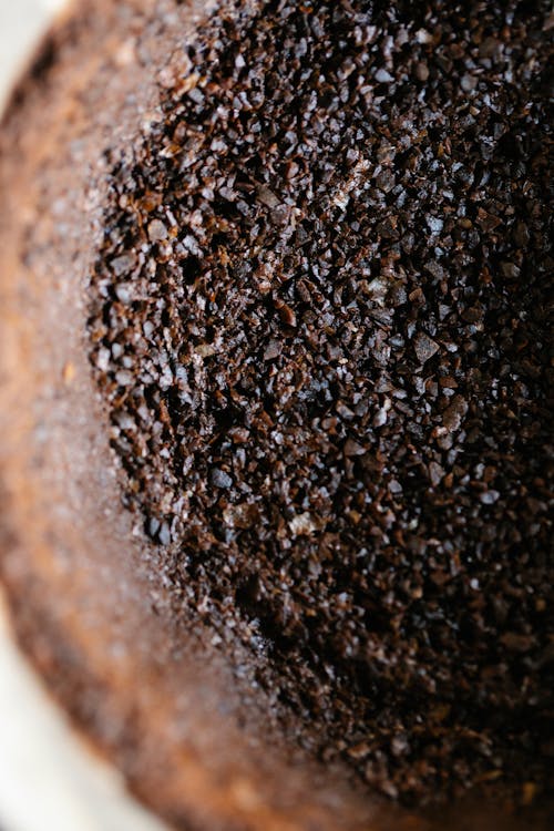 Top view closeup of aromatic roasted ground coffee in cup with paper filter in daylight