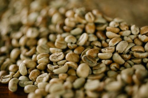 Free A detailed close-up of raw coffee beans showcasing texture and natural tones. Stock Photo