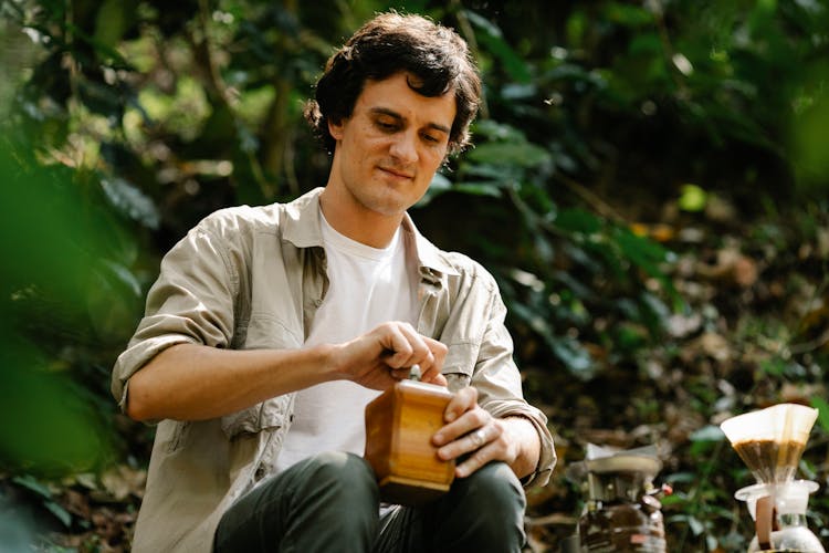 Serious Man With Coffee Grinder In Nature