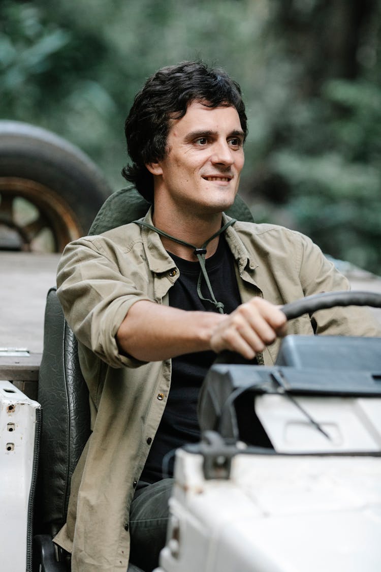 Cheerful Man Driving Car In Woodland