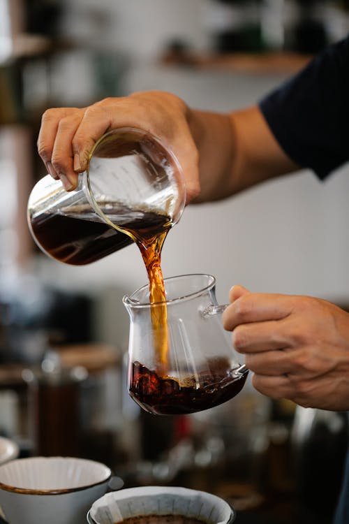 Unrecognizable bartender pouring coffee in cafe