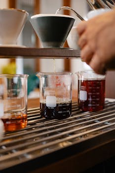 Pour-over coffee brewing captured in glass beakers, highlighting the artisanal process.