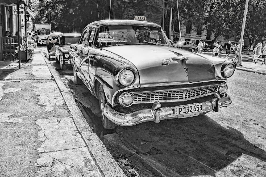 Free Grayscale Photography of Vintage Car Beside Pavement Stock Photo