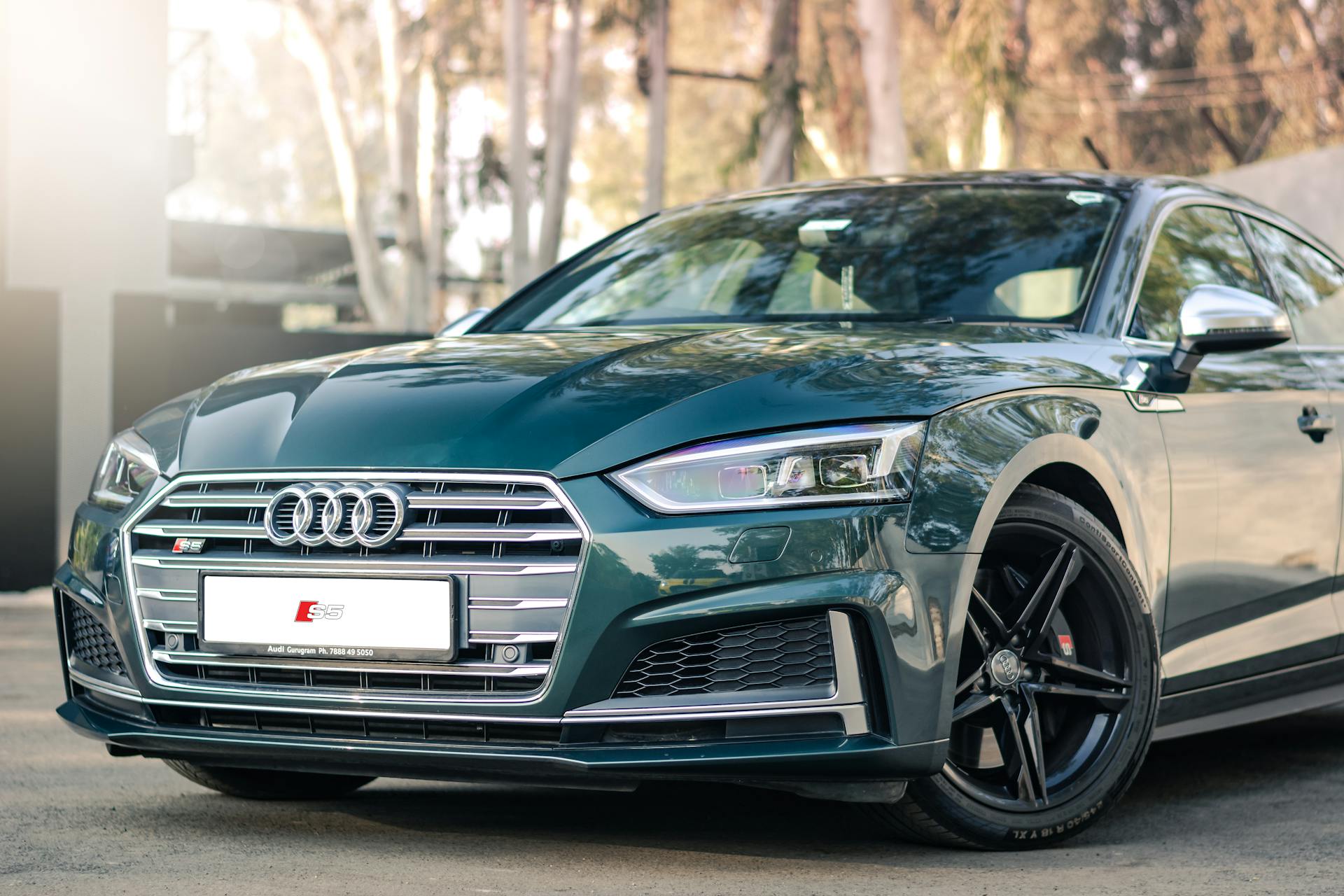 Luxurious green Audi S5 parked outdoors, showcasing its front design and polished exterior.