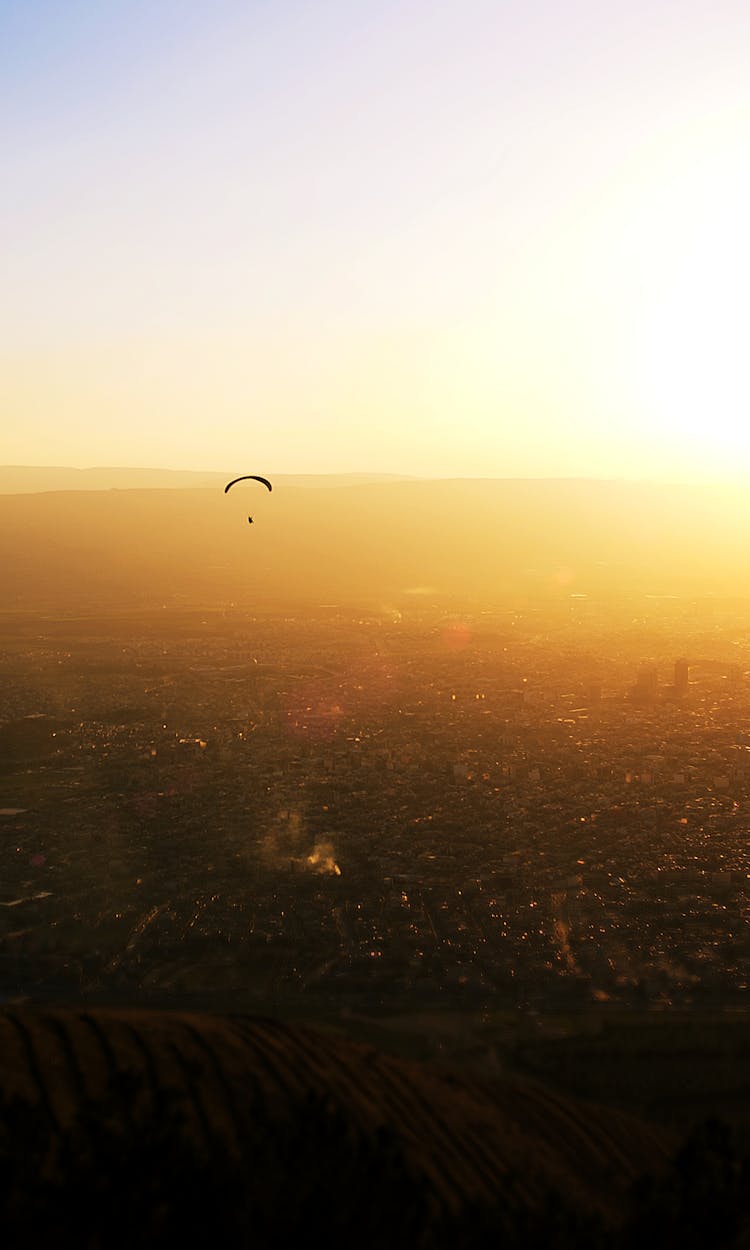 Paragliding Over City At Sunrise