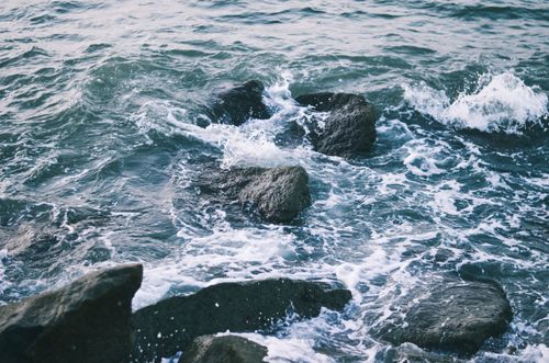 Free Dynamic ocean waves crashing against rocky shores at Malpe Beach, India, captured with vivid detail. Stock Photo
