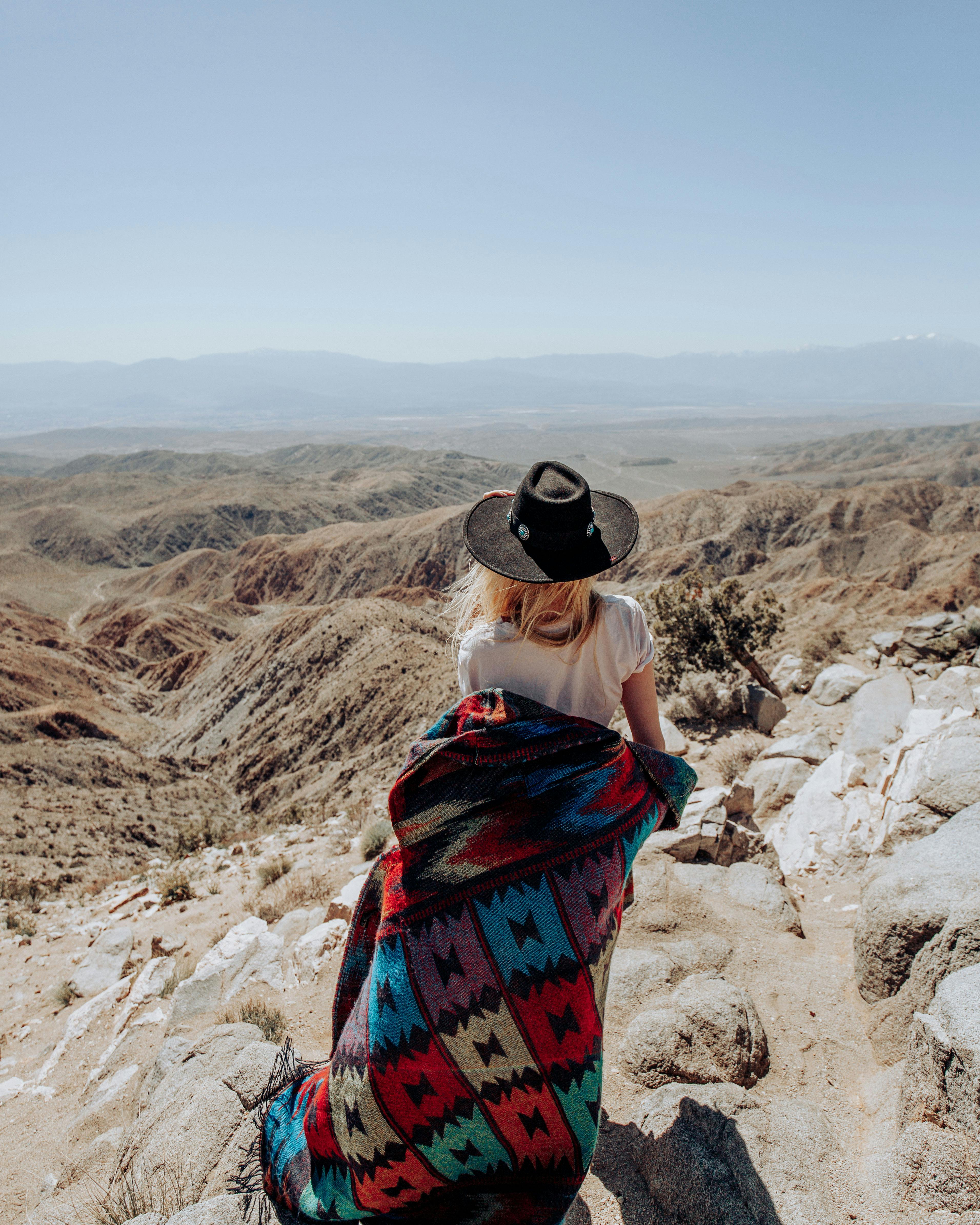 A woman wrapped in a colorful poncho enjoys a desert view in California.