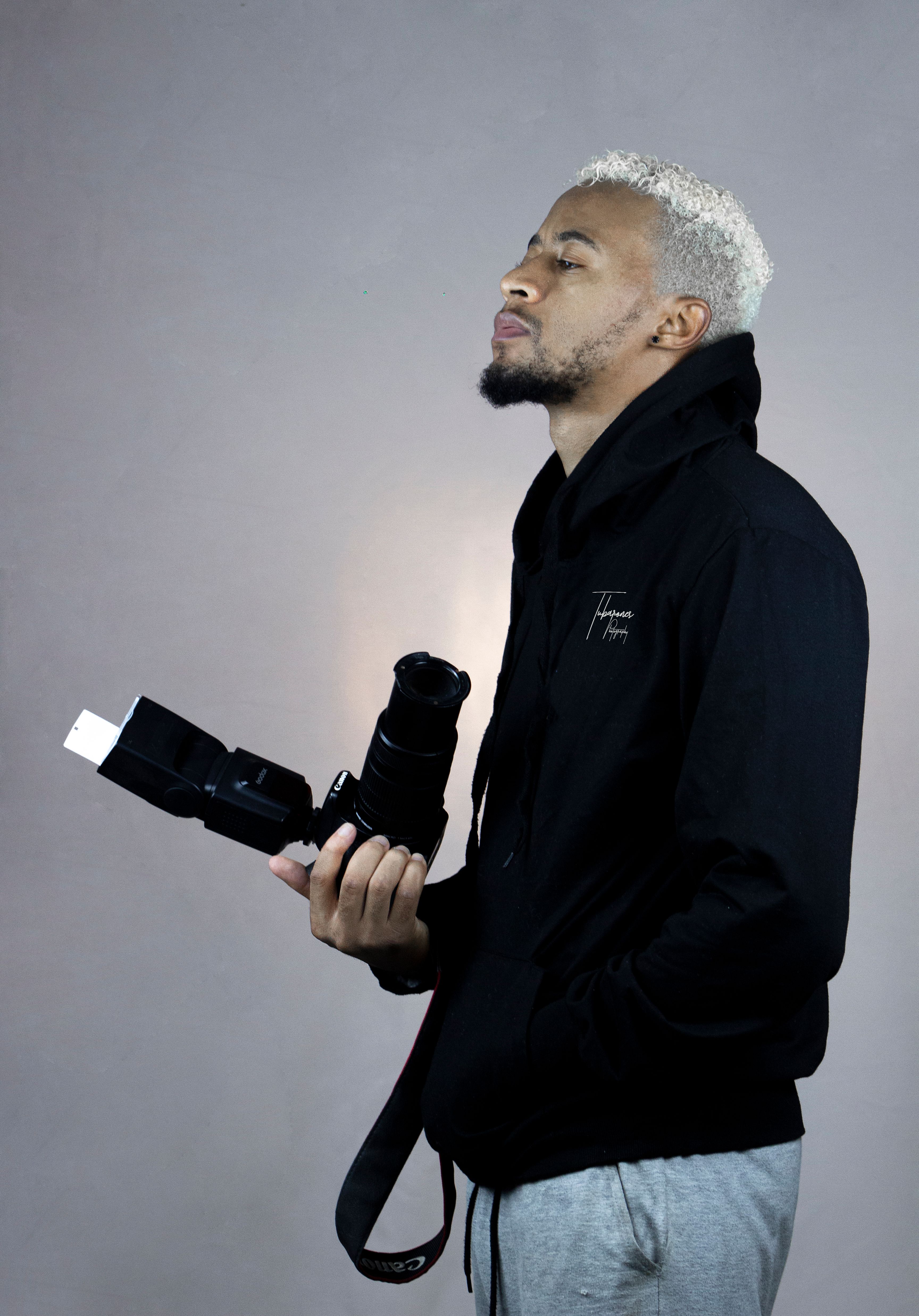 Captivating portrait of a male photographer in a studio setting, holding a camera.