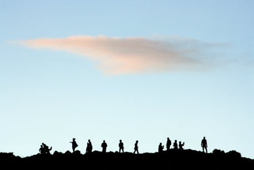 Free Silhouette of People Standing on Rock Stock Photo
