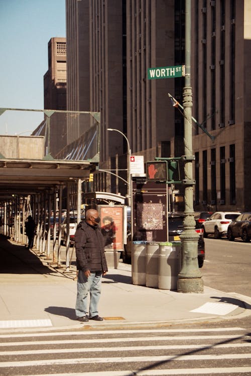 Photo of a Man Waiting Near a Pedestrian Lane