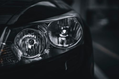 Free Detailed close-up of a car headlight showcasing design and texture in black and white. Stock Photo