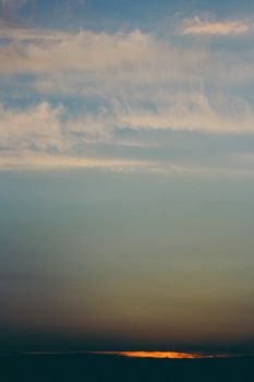 A stunning vertical shot of a dramatic sunset sky, showcasing vibrant colors and wispy clouds.