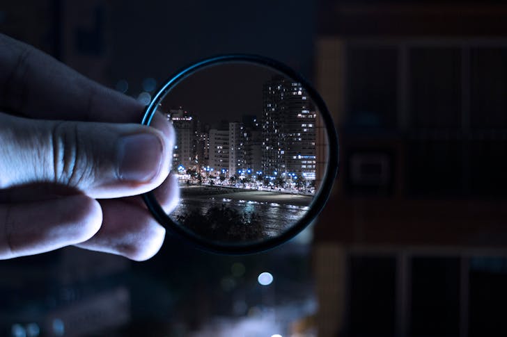 Person Holding Magnifying Glass