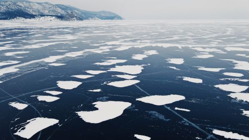 Free A stunning aerial view of a frozen lake with snow patches during winter in Siberia, Russia. Stock Photo