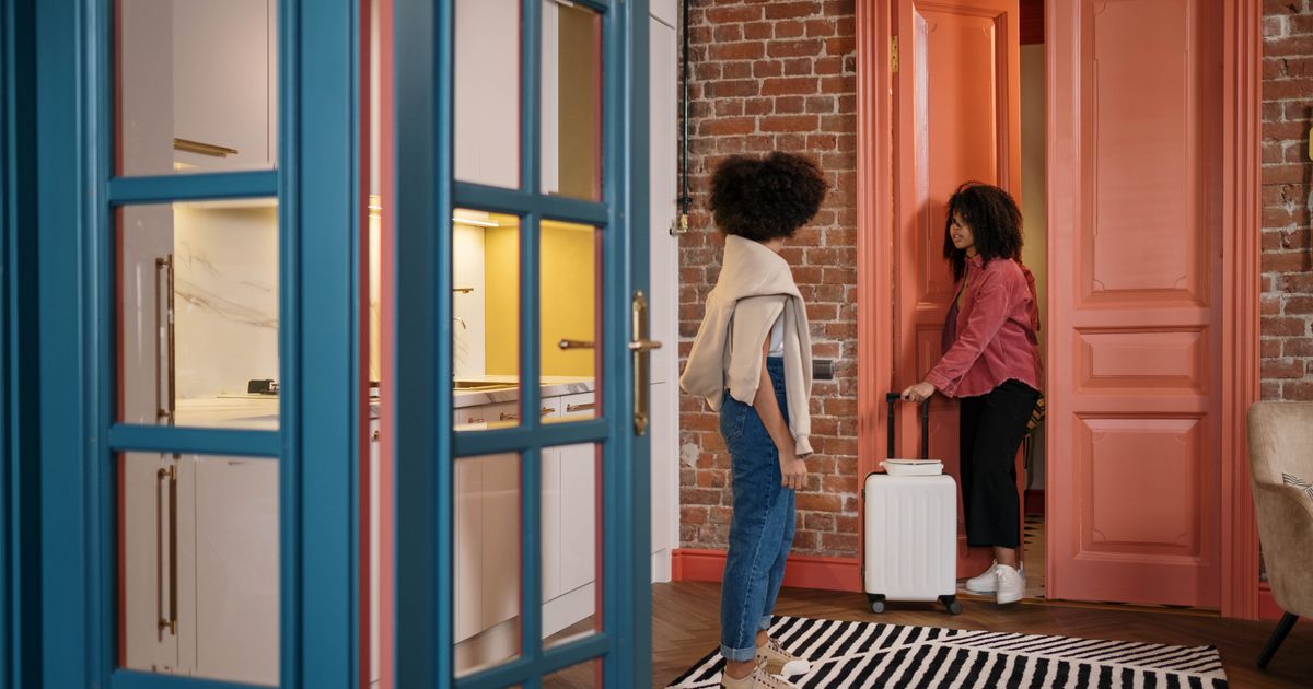 Voyageuses avec leurs valises dans le couloir d'un appartement
